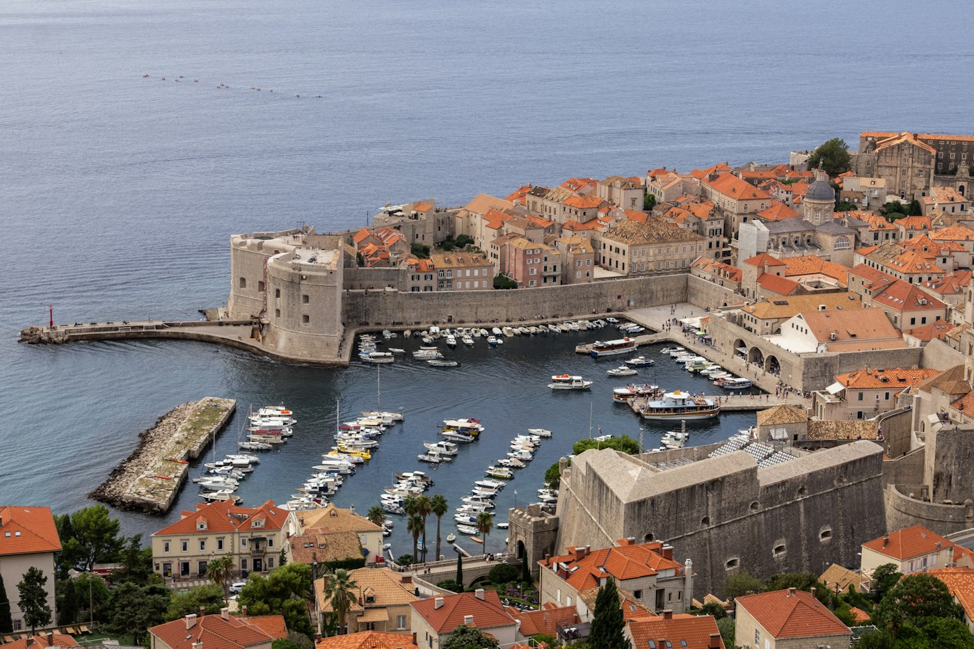 Dubrovnik old harbour surrounded by stone city walls and terracotta rooftops